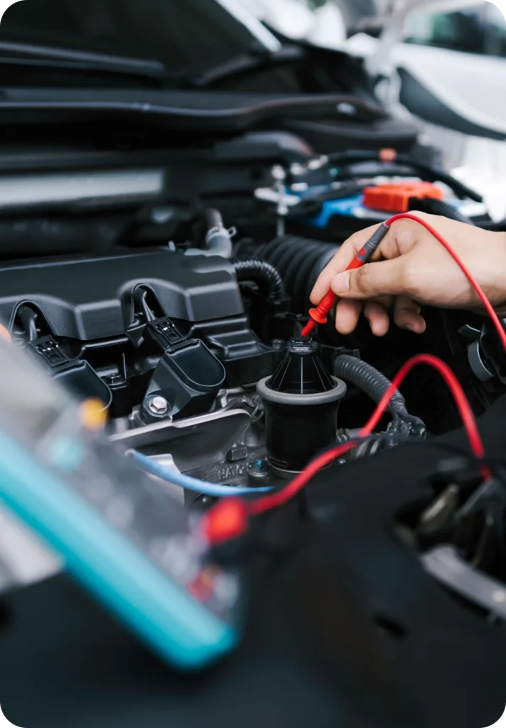 Mekaniker mäter med multimeter i bilens motorrum